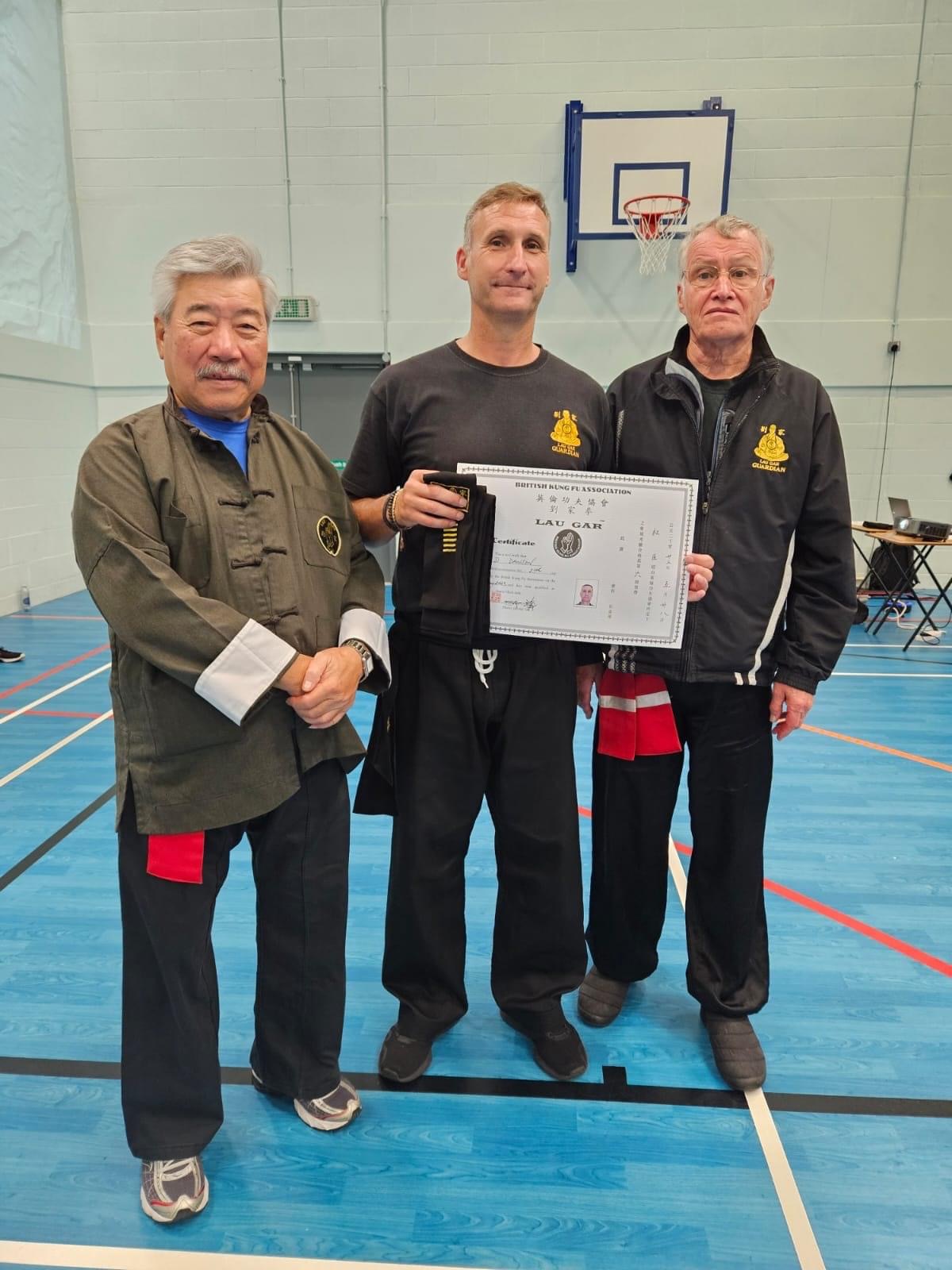 Our Sifu and Guardian Derek Dawson receiving his 6th Degree Black Sash and Certificate from Grand Master Yau and Master Russell.
