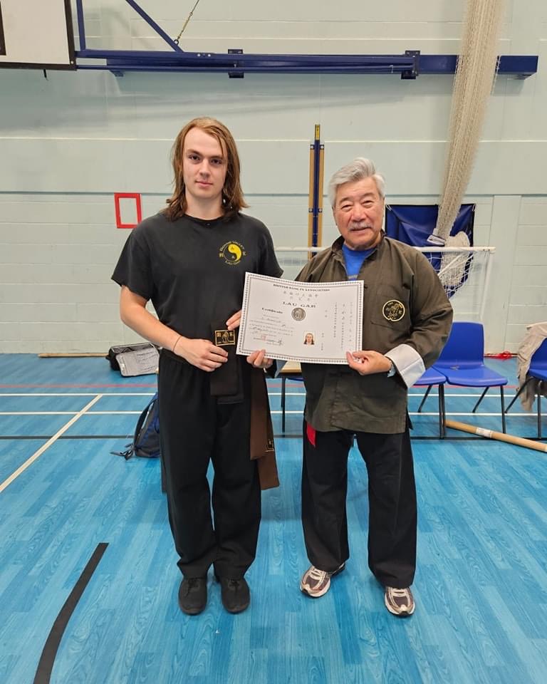 Dawid Szewzyk receiving his Black Sash and Certificate from Grand Master Yau.